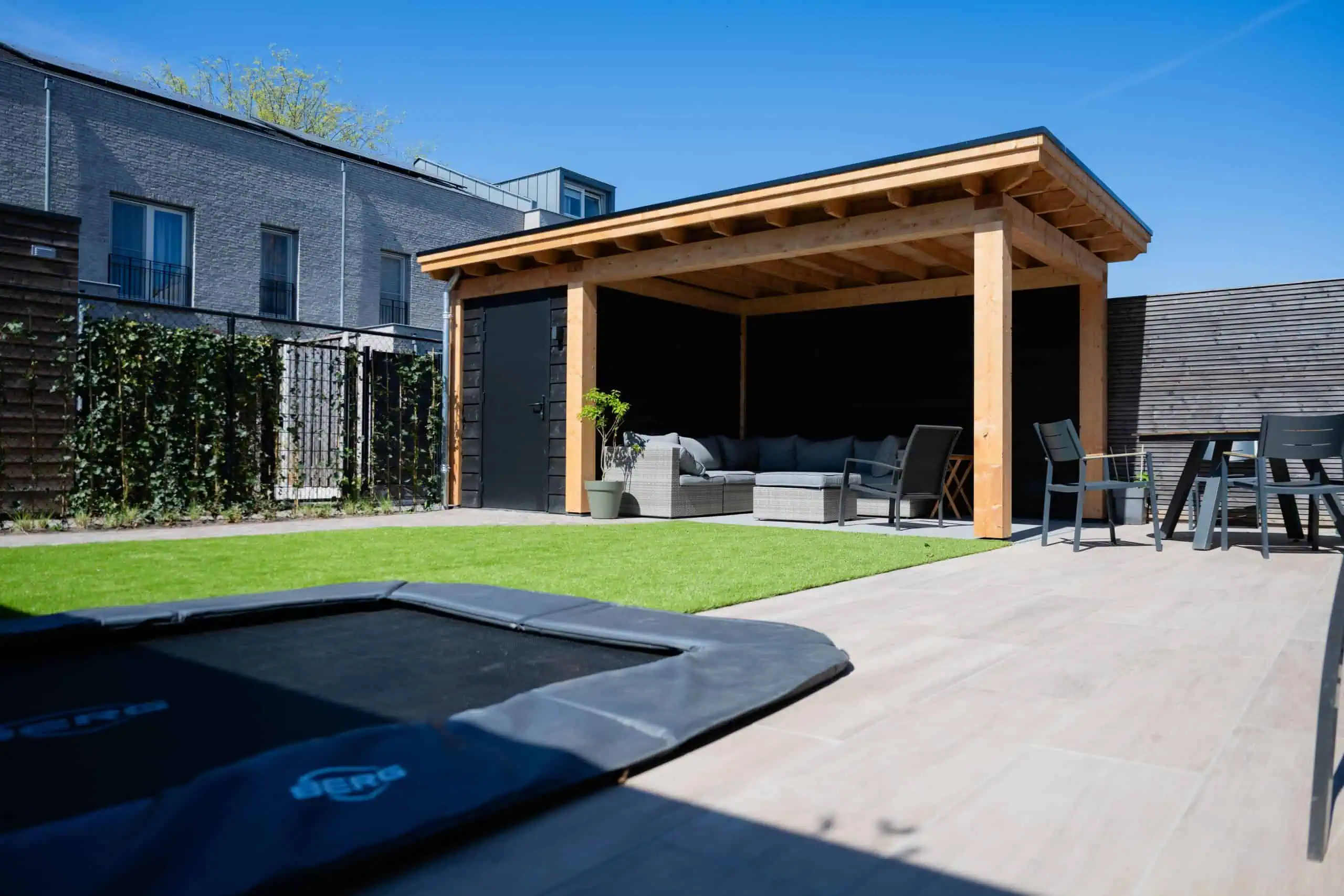 Kindvriendelijke tuin met kunstgras en een ingegraven trampoline in Eindhoven